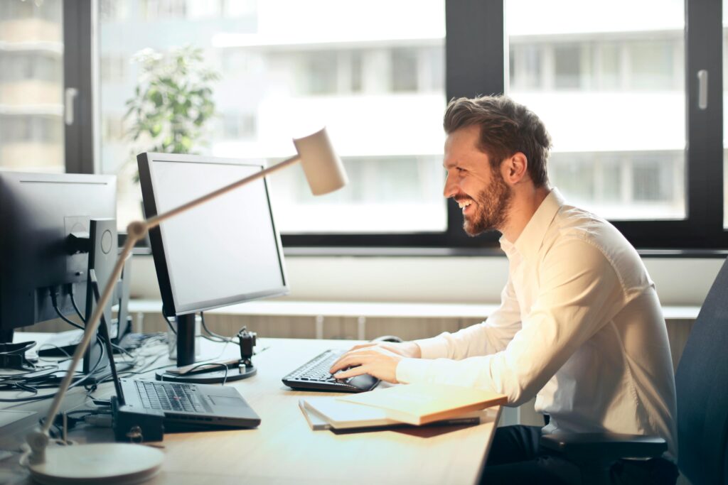 Uomo che sorride al computer