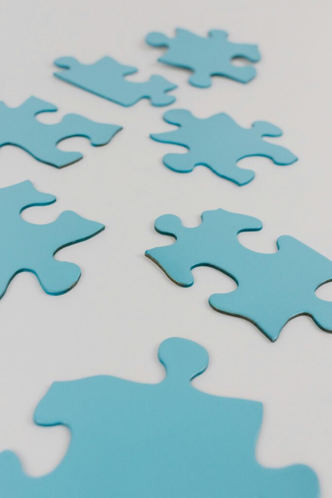 pexels-photo-8385738-8385738 Close-up of blue puzzle pieces on a white surface, concept of problem-solving and integration.